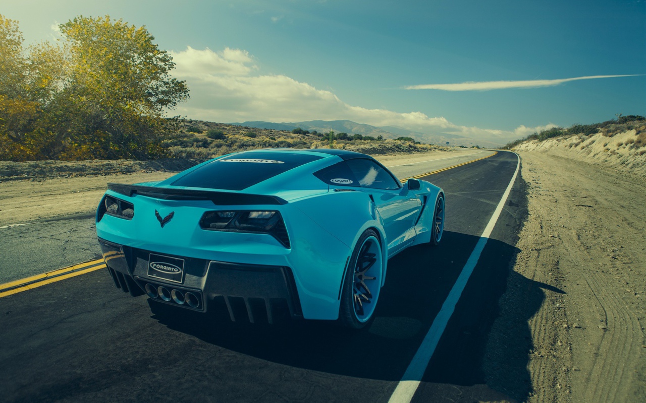 Голубой спортивный Chevrolet на шоссе в жаркой пустыне