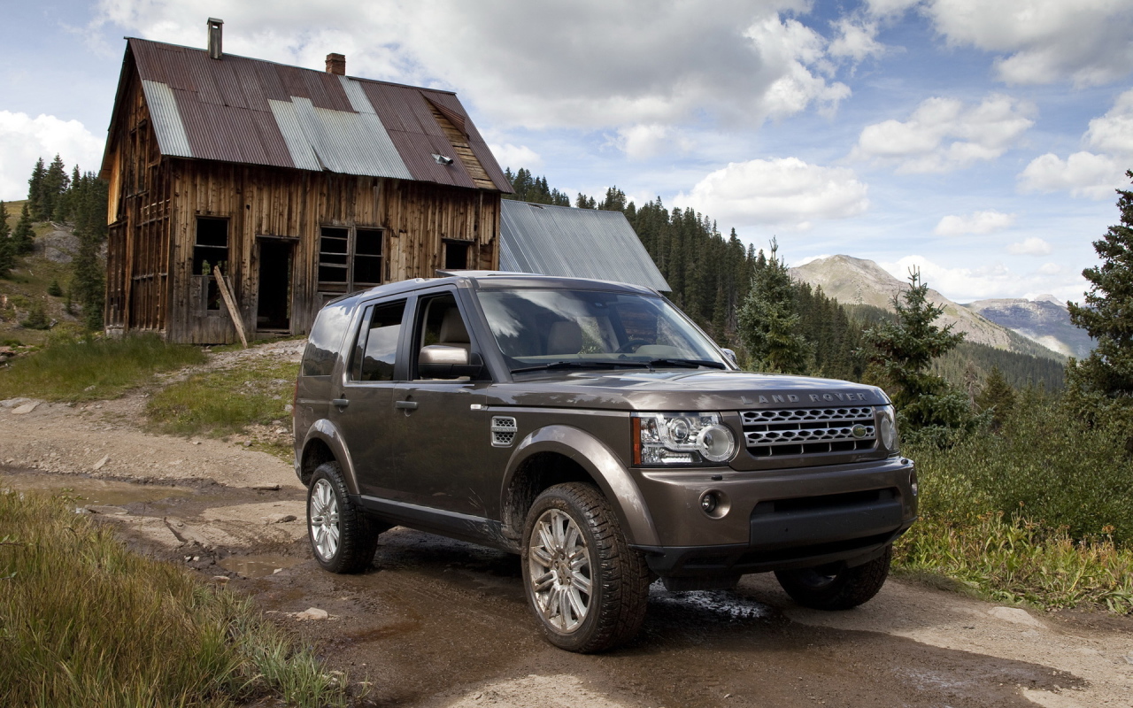 Темный Land Rover на фоне старого здания