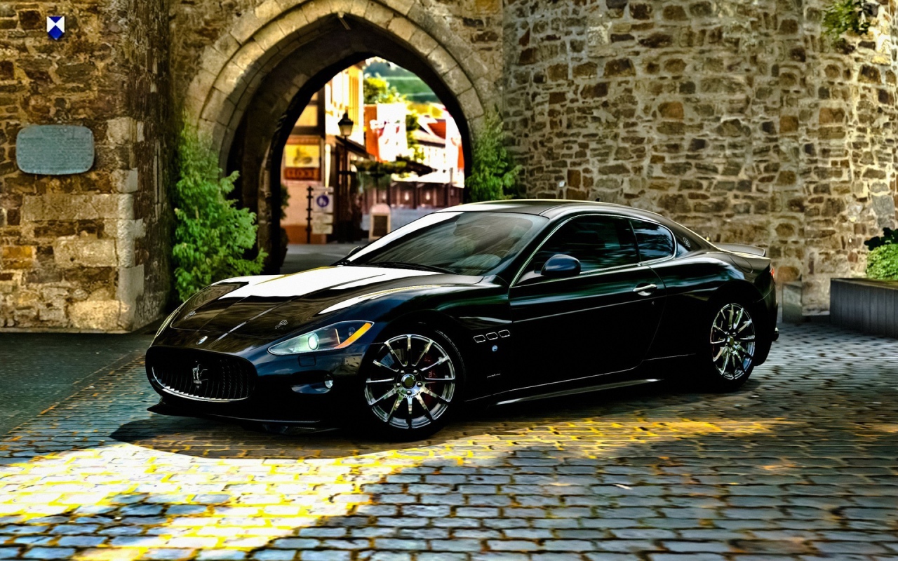 Черный Maserati gran turismo у каменной арки