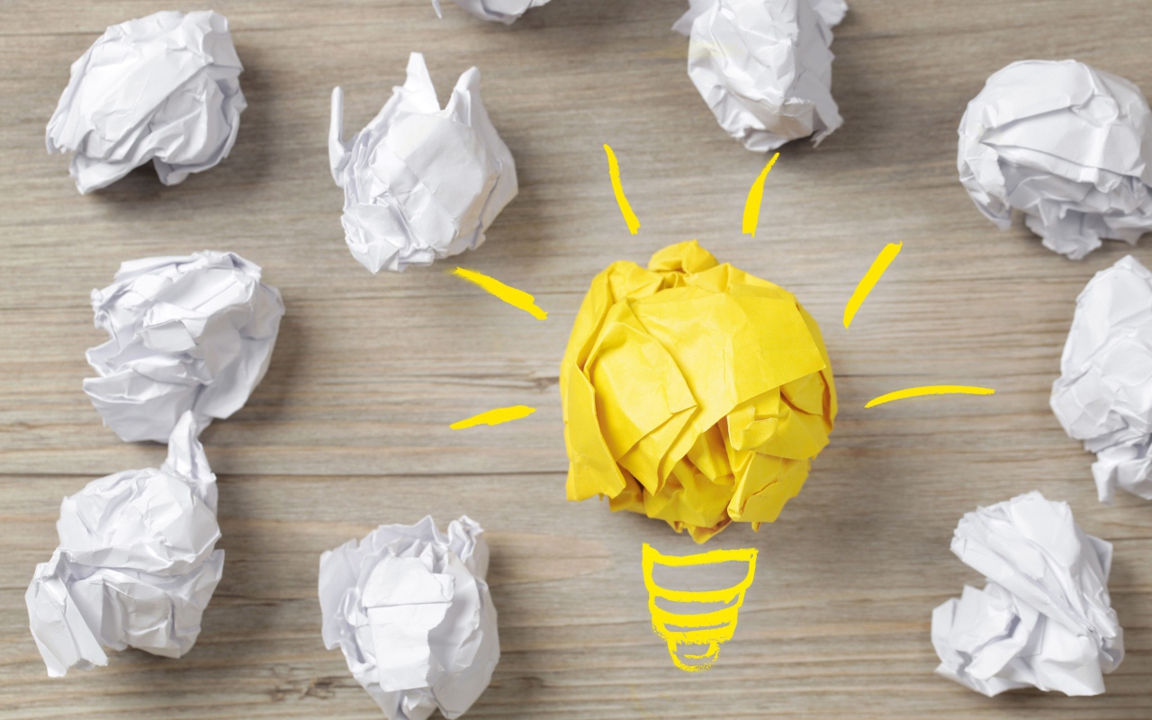 Комок желтой бумаги среди белых