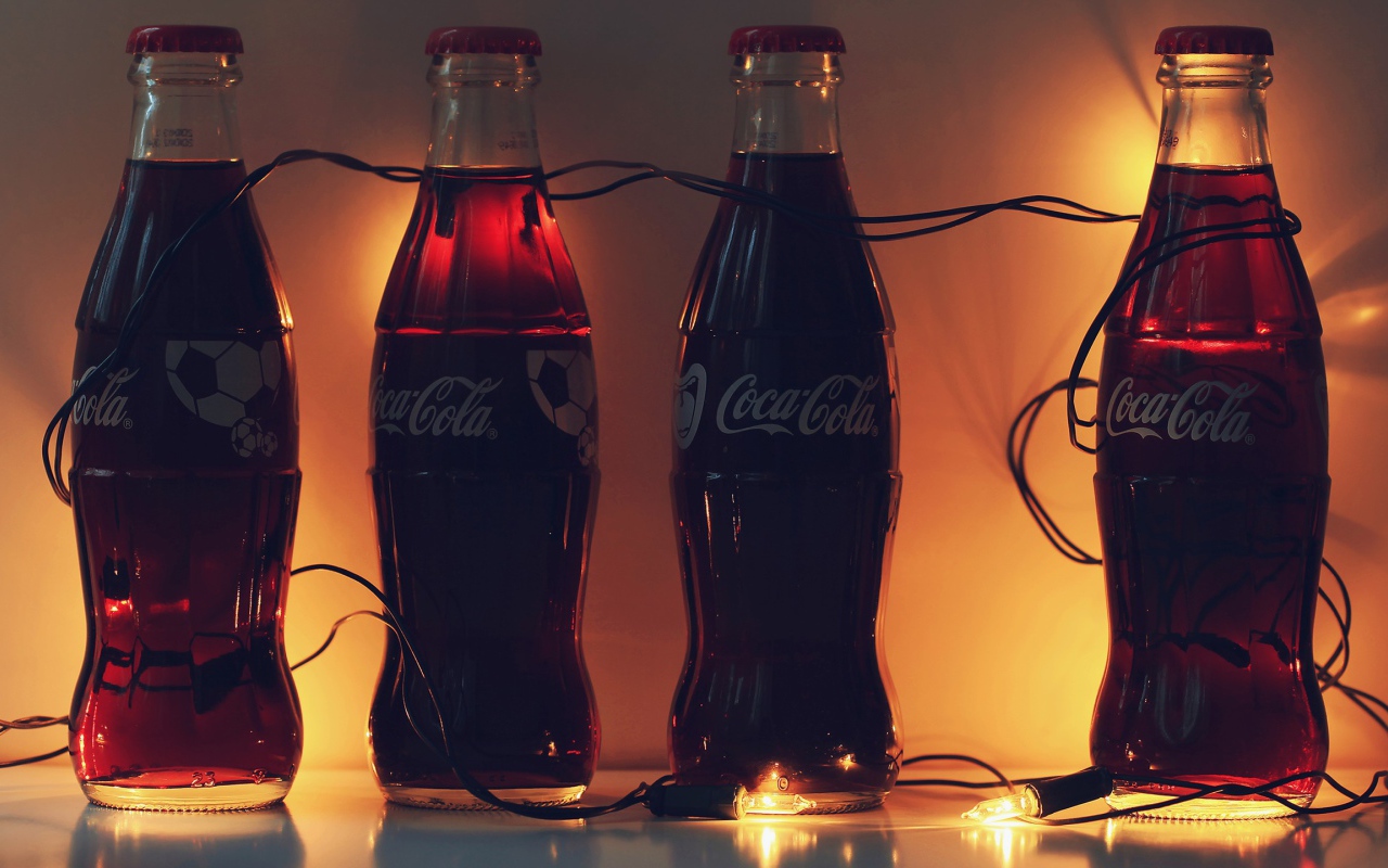 Бутылки Кока-Колы связанные новогодней гирляндой