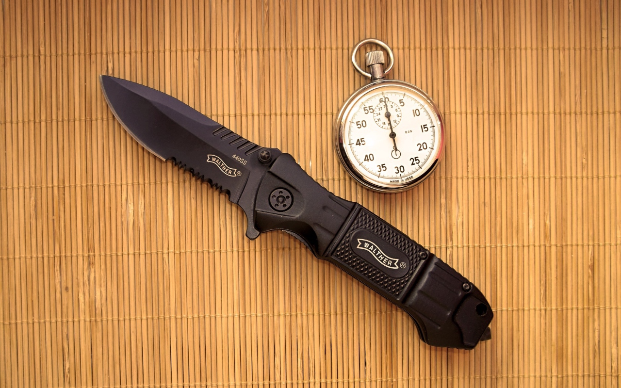 Часы и нож на бамбуковом коврике