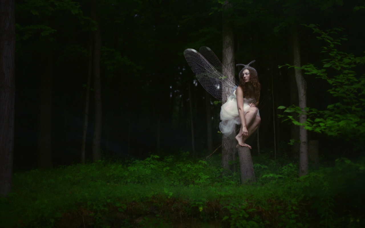 Девушка фея среди деревьев в чаще леса