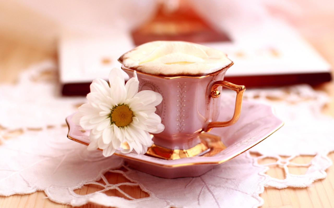 Кофе с пенкой и ромашка на блюдце