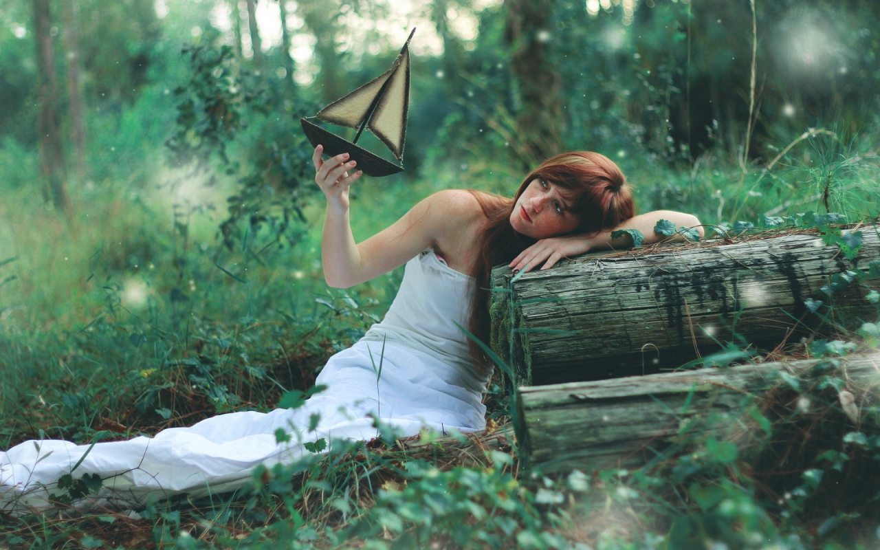 Девушка в белом платье держит в руке кораблик