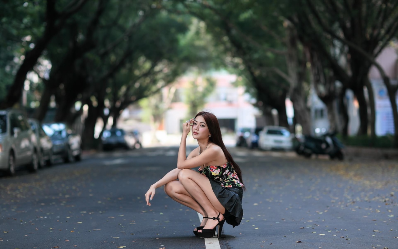 Азиатская девушка сидит на корточках