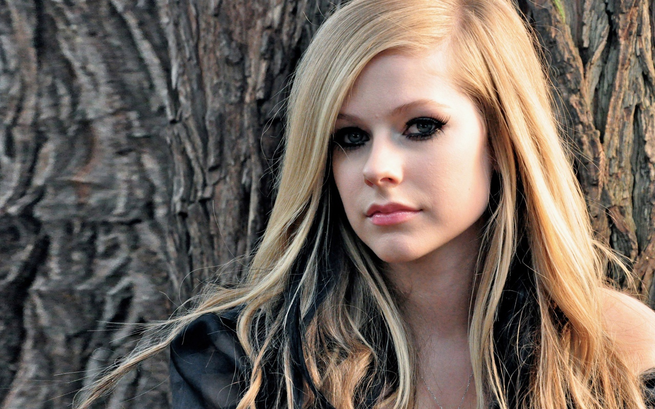 Блондинка Аврил Лавин на фоне коры дерева