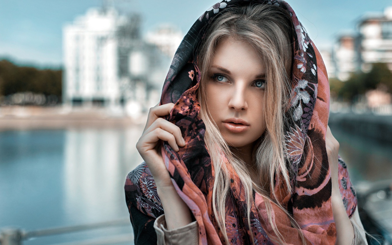 Блондинка в накидке на фоне городского пруда