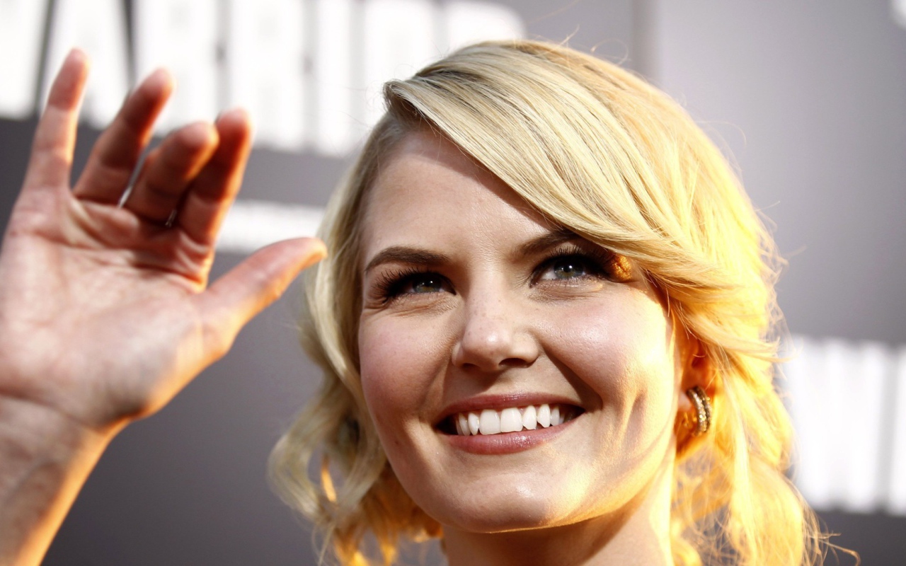 Блондинка улыбается и машет