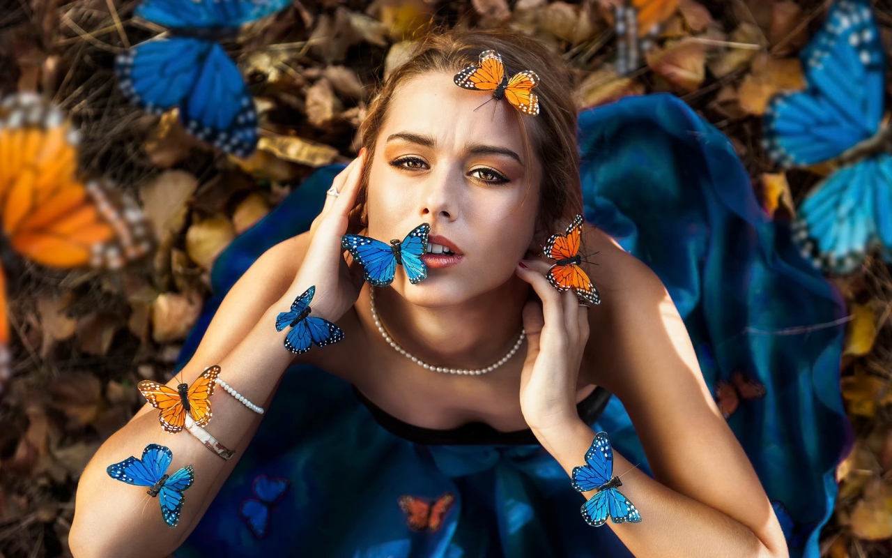 Голубые и оранжевые бабочки на девушке