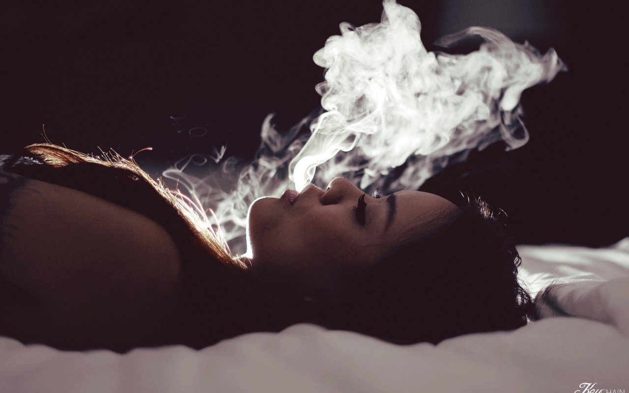 Девушка выпускает дым изо рта