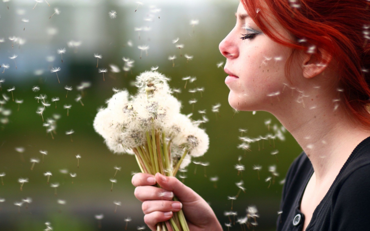 Девушка держит в руках букет одуванчиков