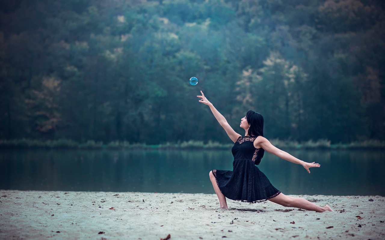 Девушка в черном платье и мыльный пузырь