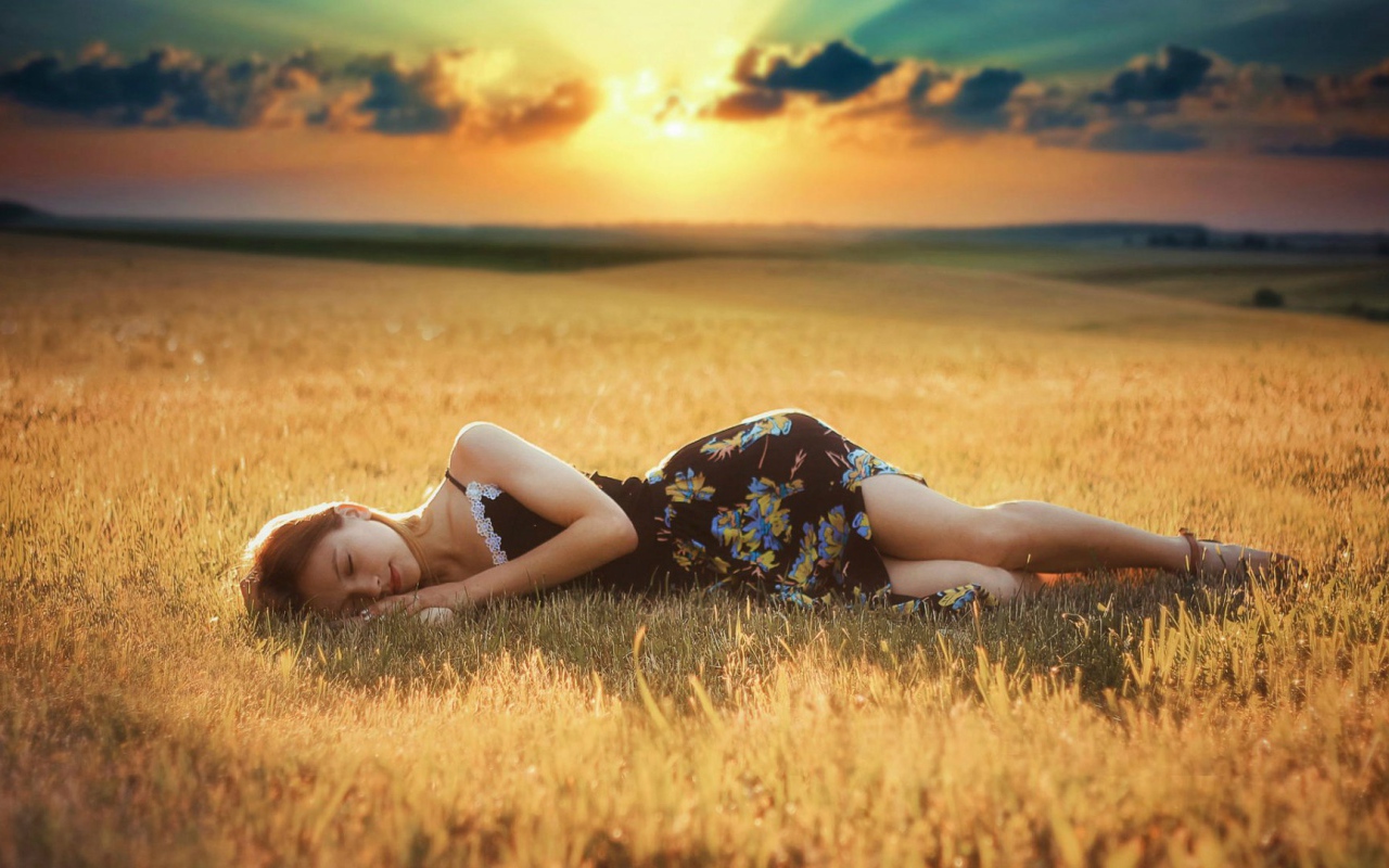 Girl lies on a sloping field