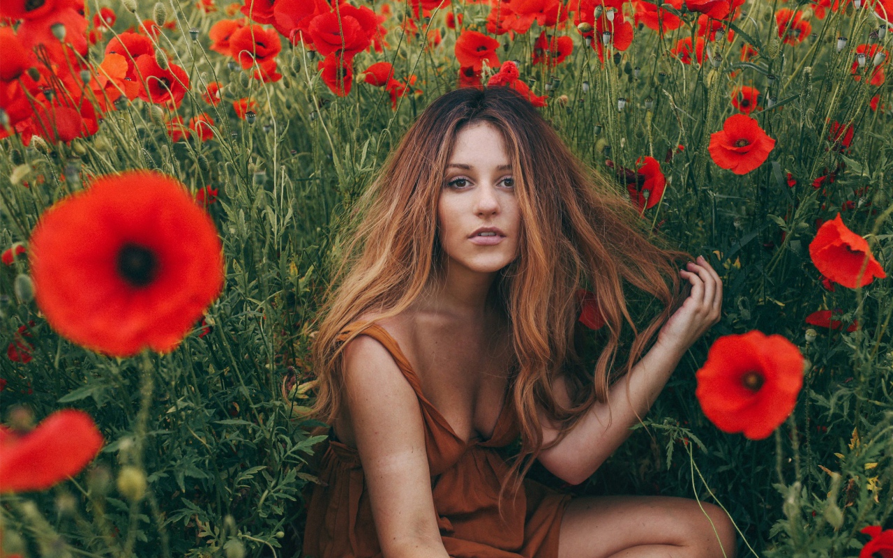 Girl with her hair among poppies