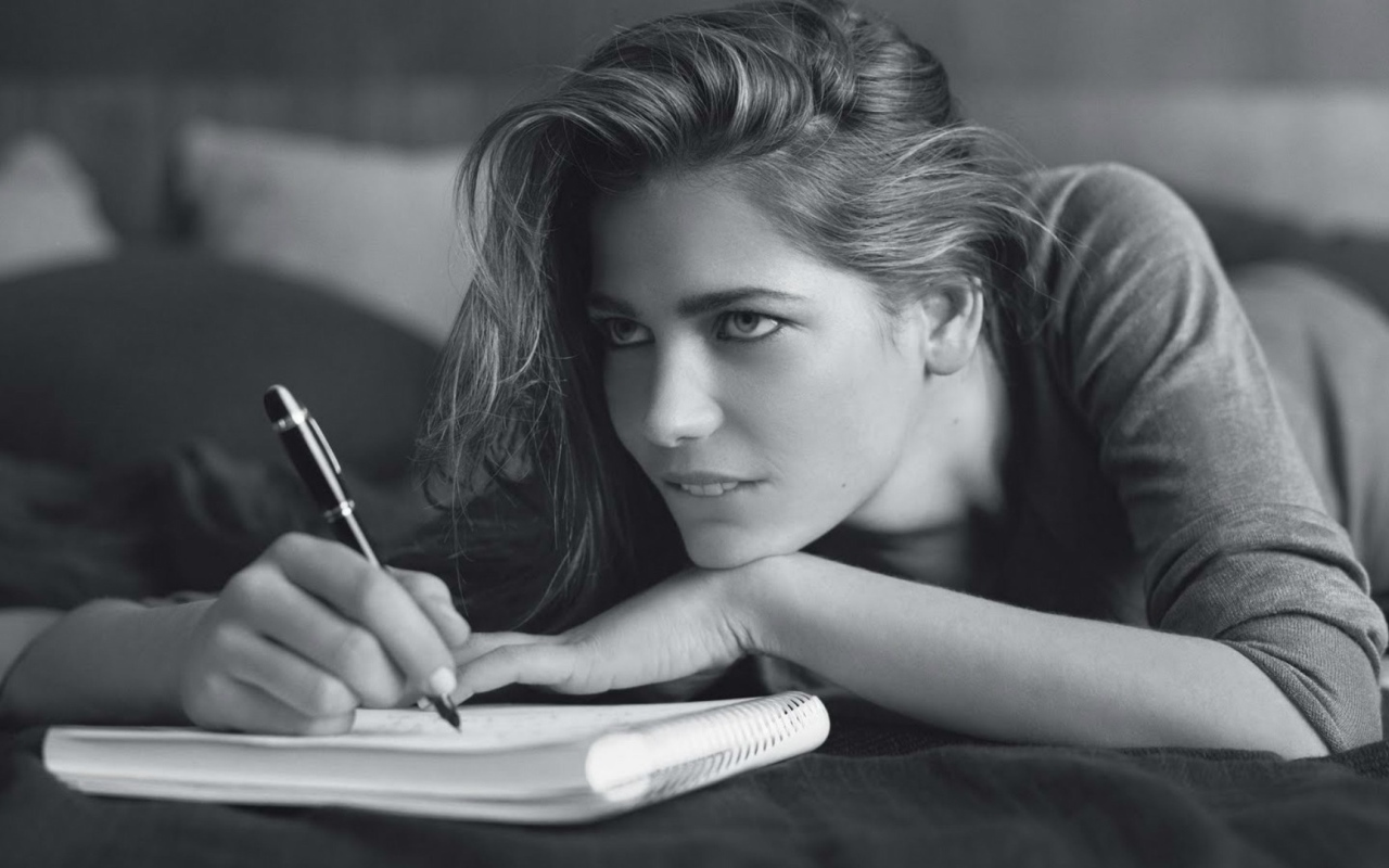 Девушка пишет в блокноте