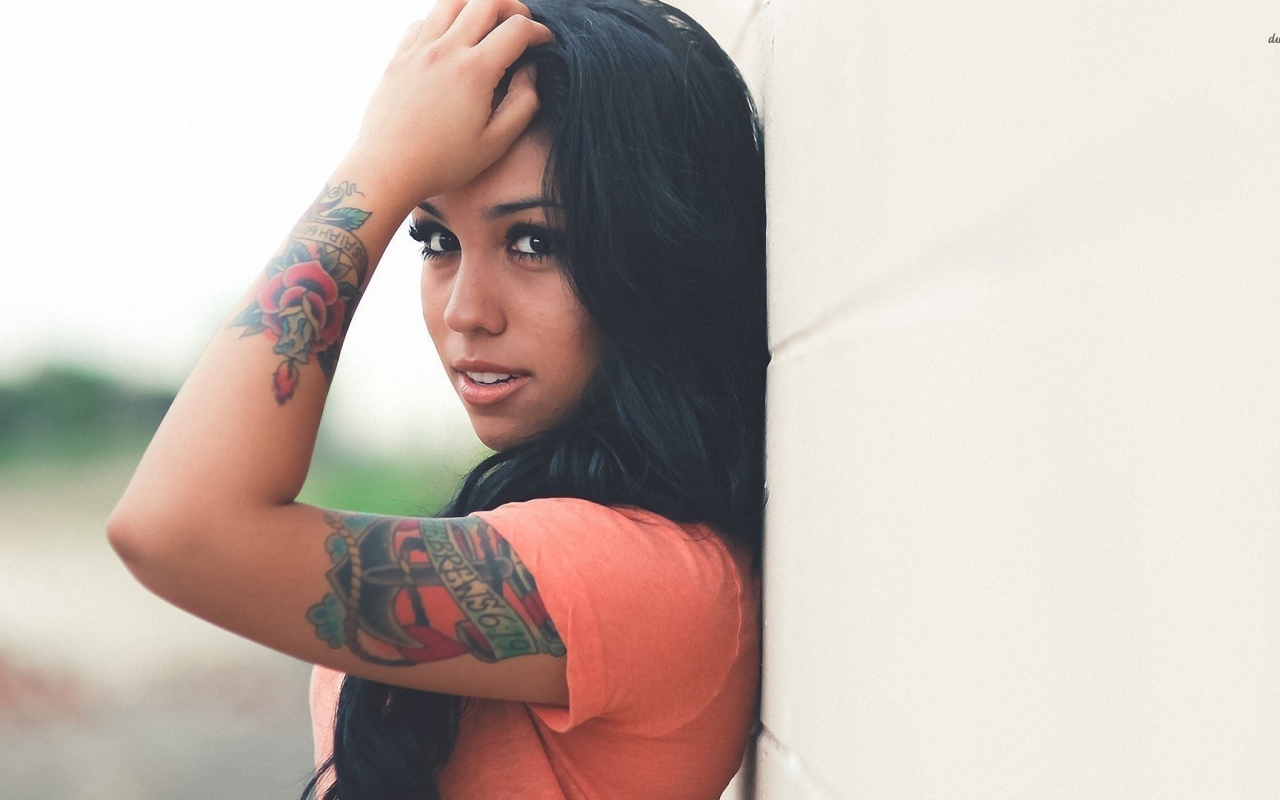 Страстная длинноволосая брюнетка прислонилась к стене