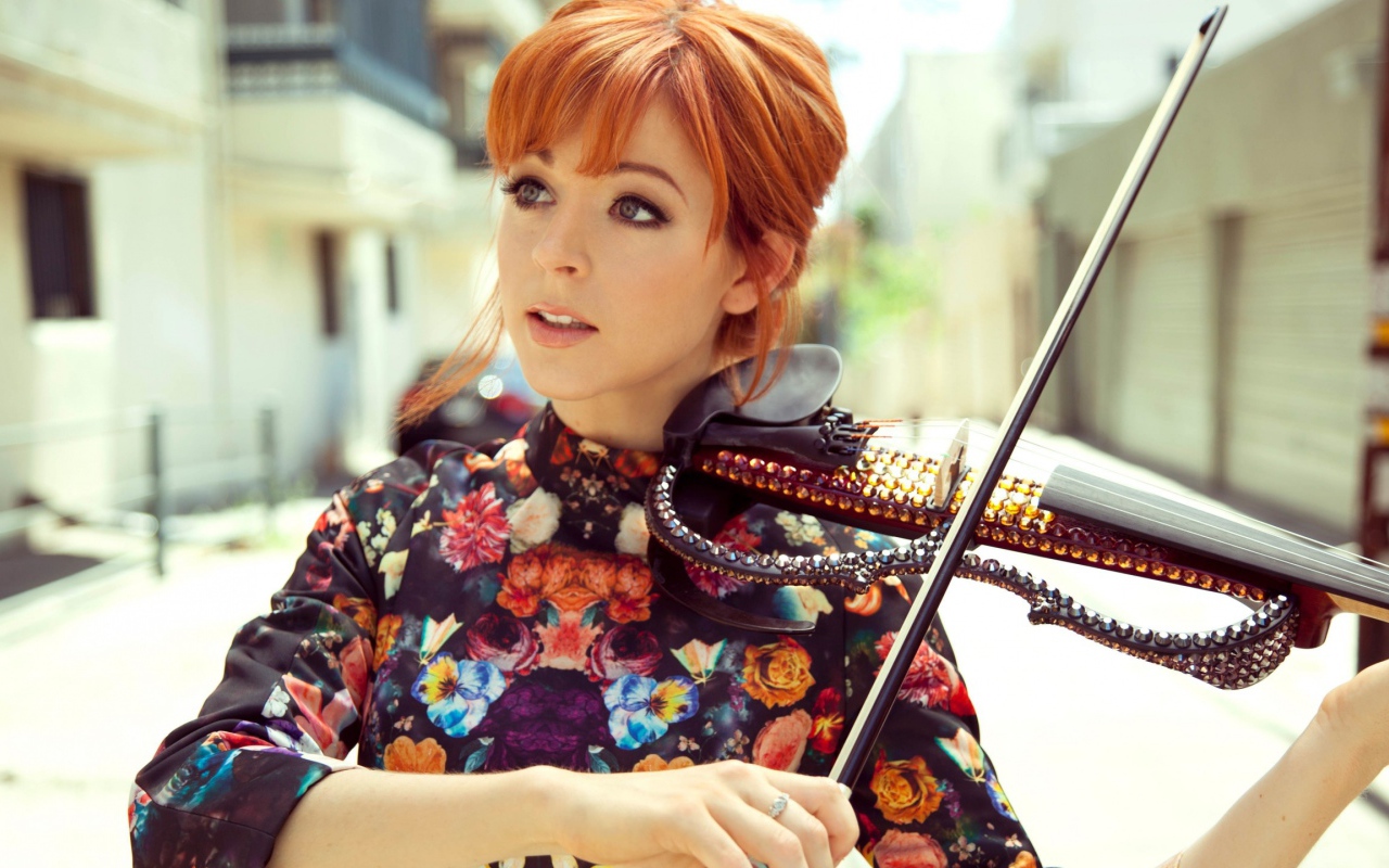 Рыжая девушка играет на скрипке со стразами