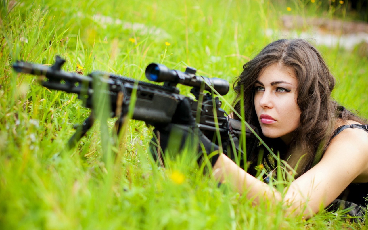 Девушка снайпер залегла в траве