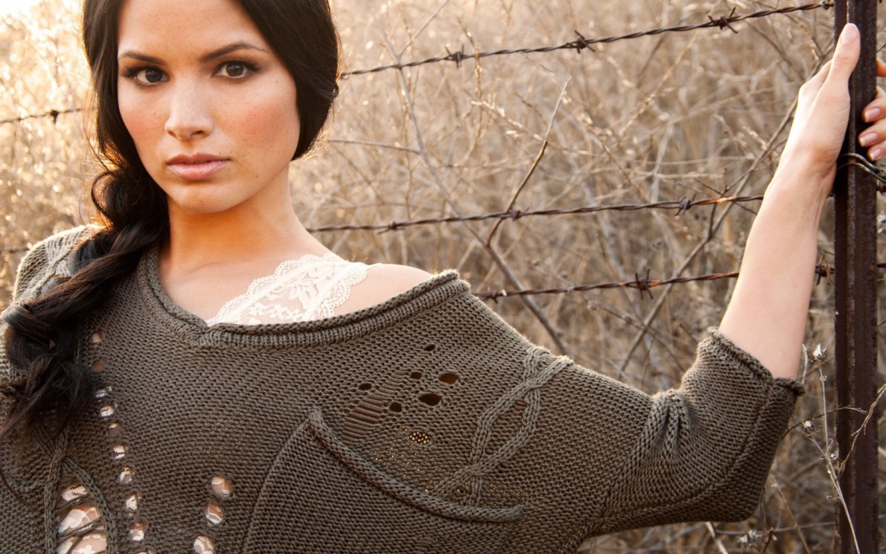 Девушка у забора из колючей проволоки