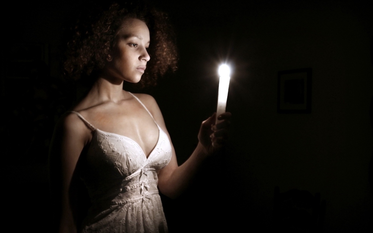 Девушка со свечой в темноте
