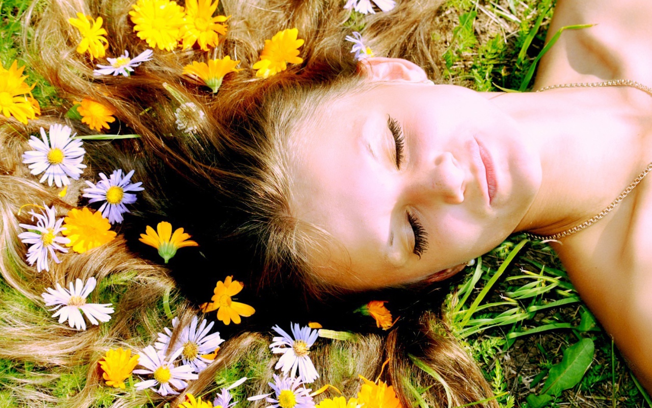 Белые и желтые цветы в волосах у девушки