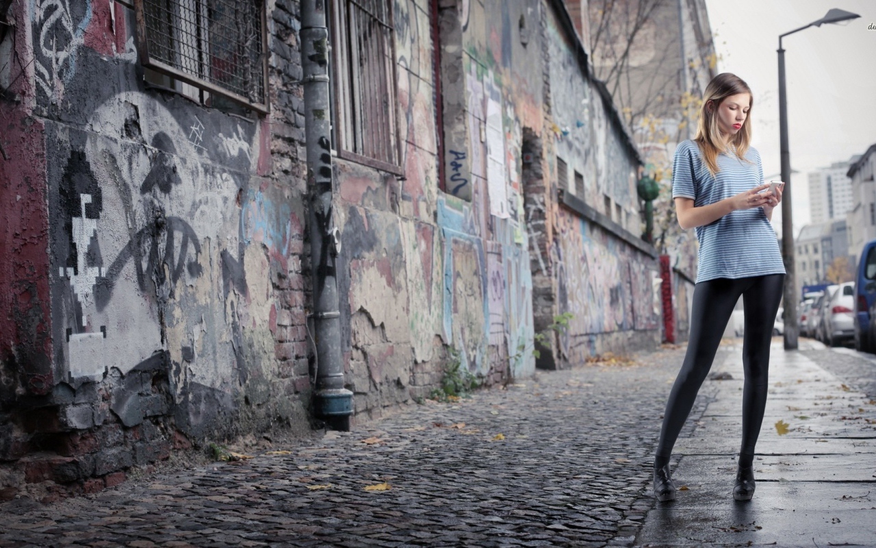 Молодая девушка стоит на улице в трущобах