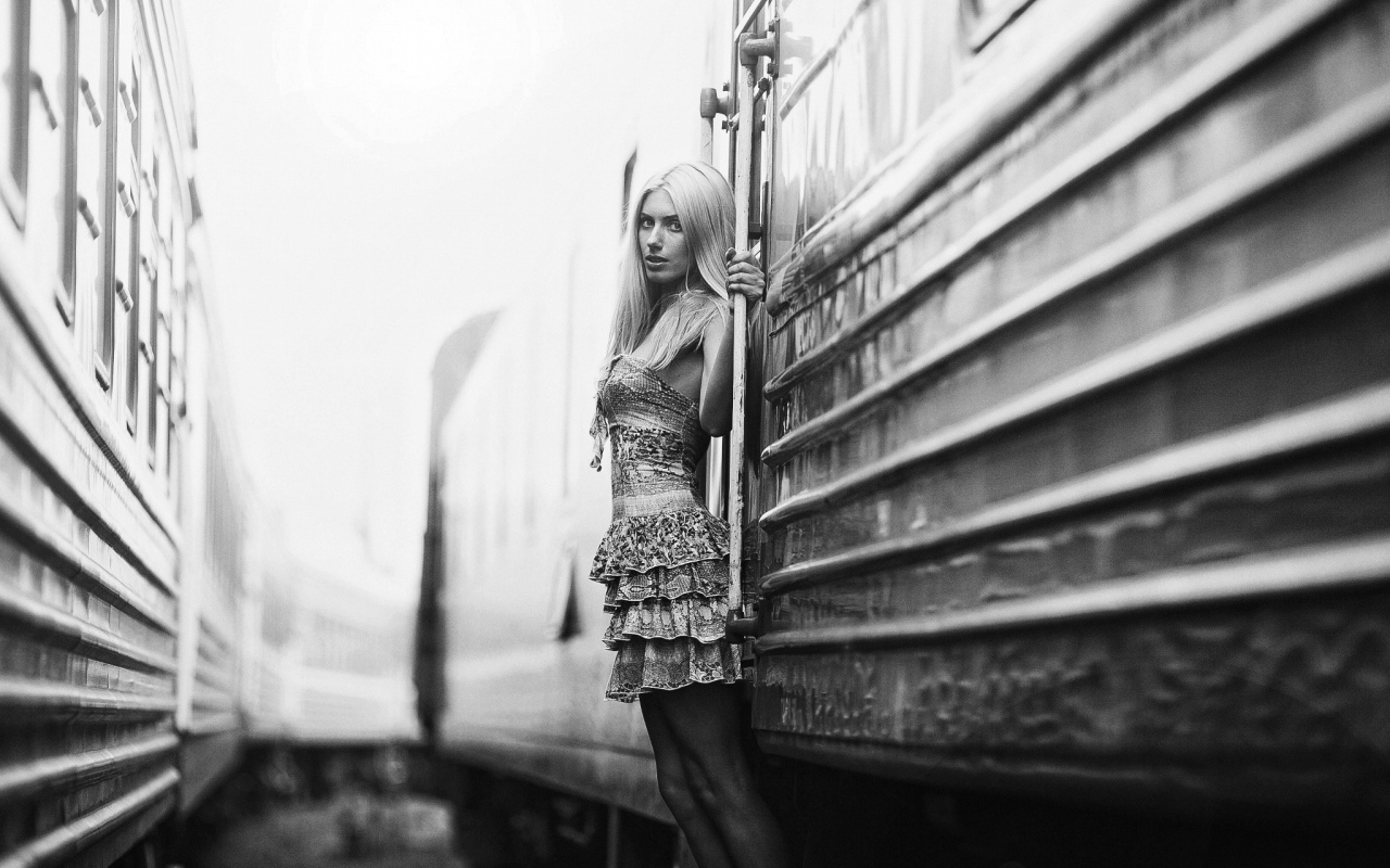 Модель стоит у входа в вагон, черно белое фото