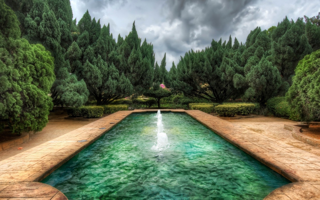 Пруд с фонтанами в саду