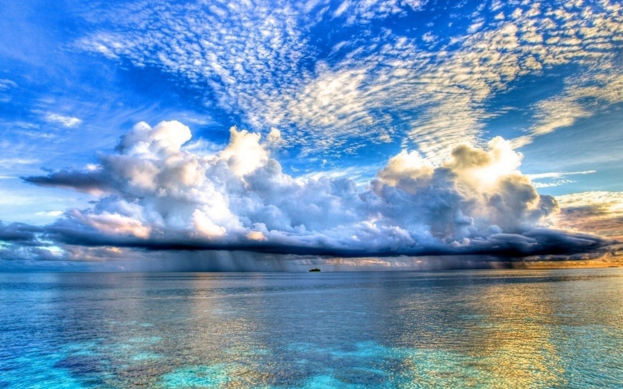 Разные облака над островком в океане