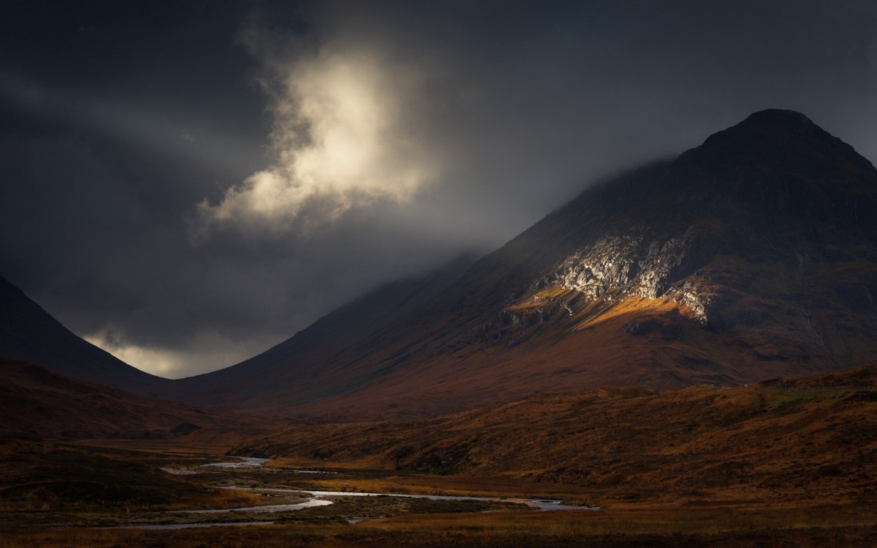 Луч солнца освещает часть склона горы