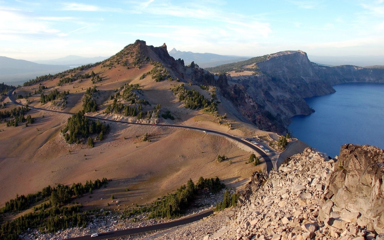 Шоссе огибает скалы у озера в горах