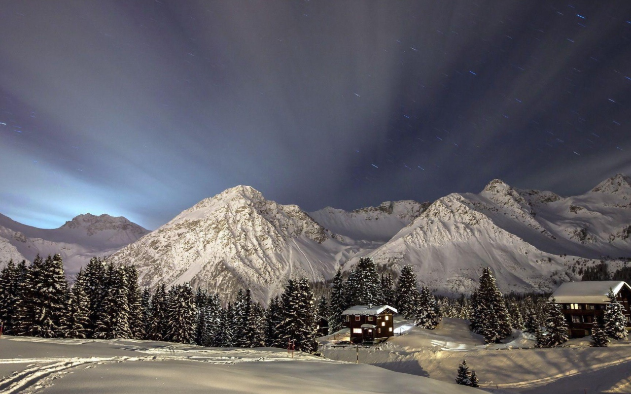 Лучи света над заснеженными горами