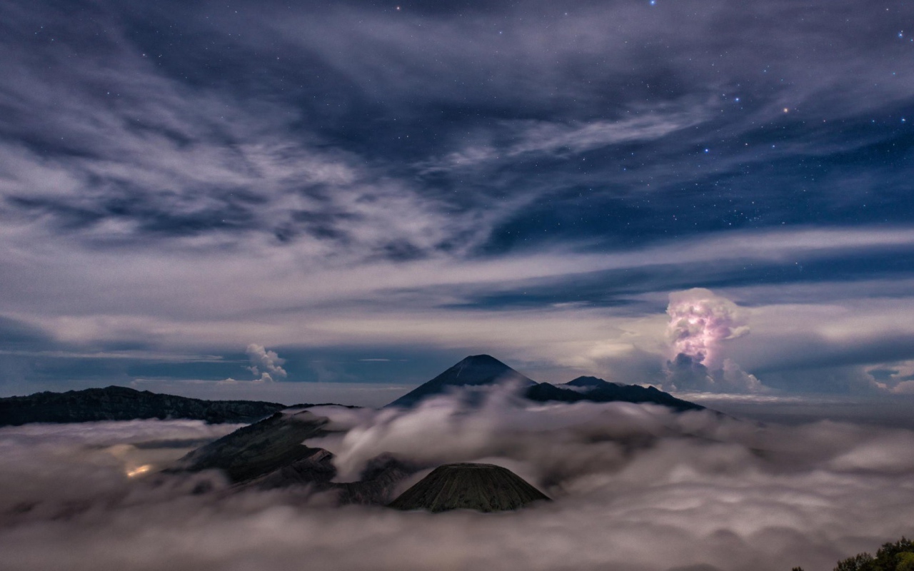 Звездное небо над облаками и туманом в горах