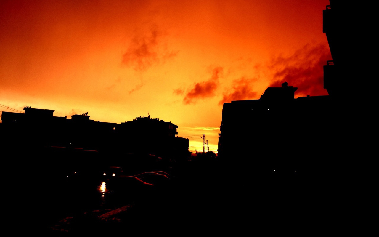 Силуэты зданий на фоне оранжевого неба