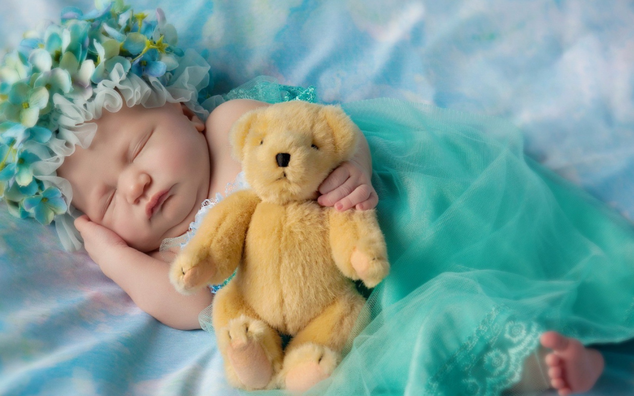 Ребенок спит с медвежонком в руке