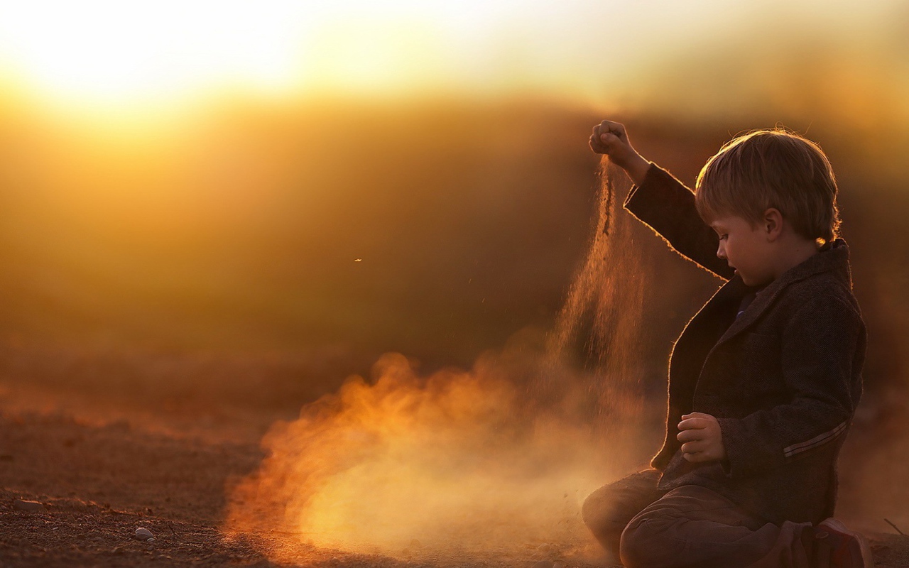 Мальчик играет песком