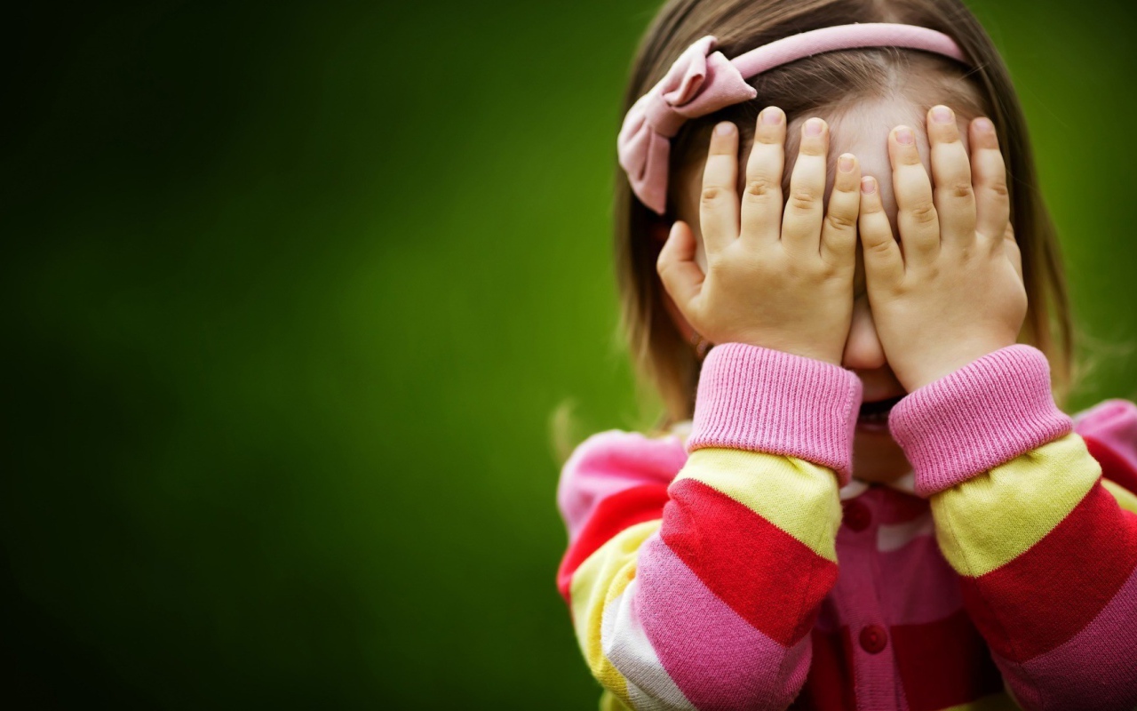 Милая девочка закрыла лицо руками