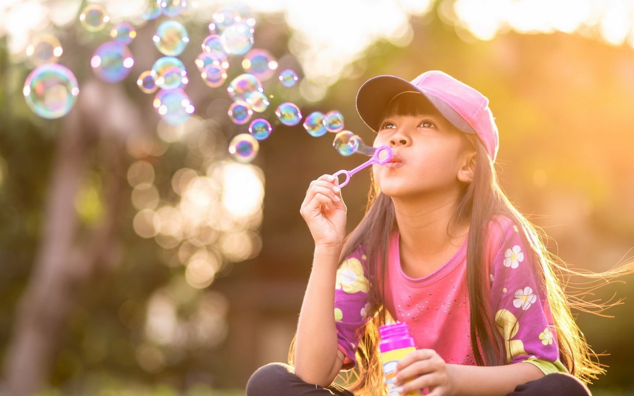 Девочка запускает мыльные пузыри