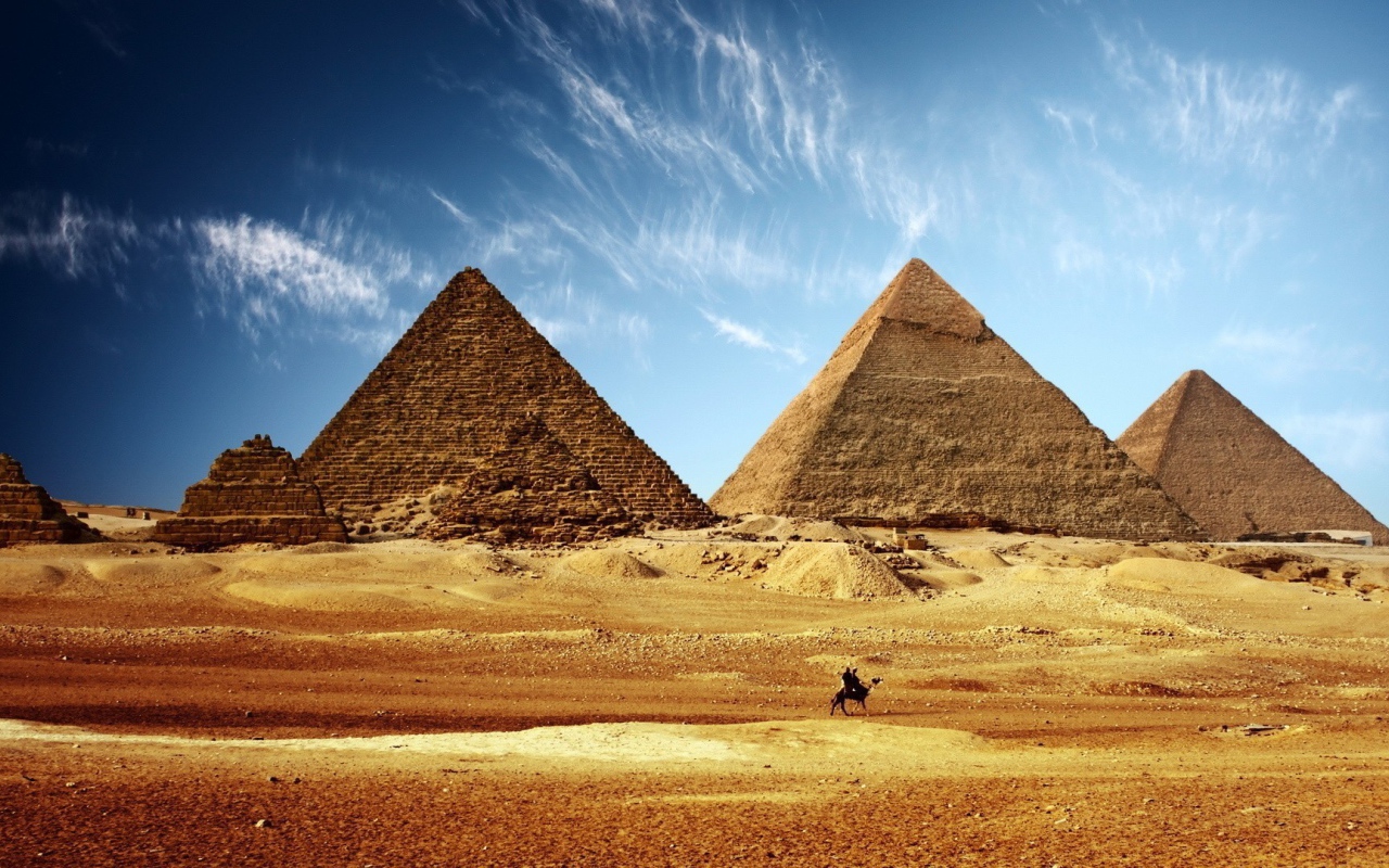 Одинокий верблюд на фоне пирамид