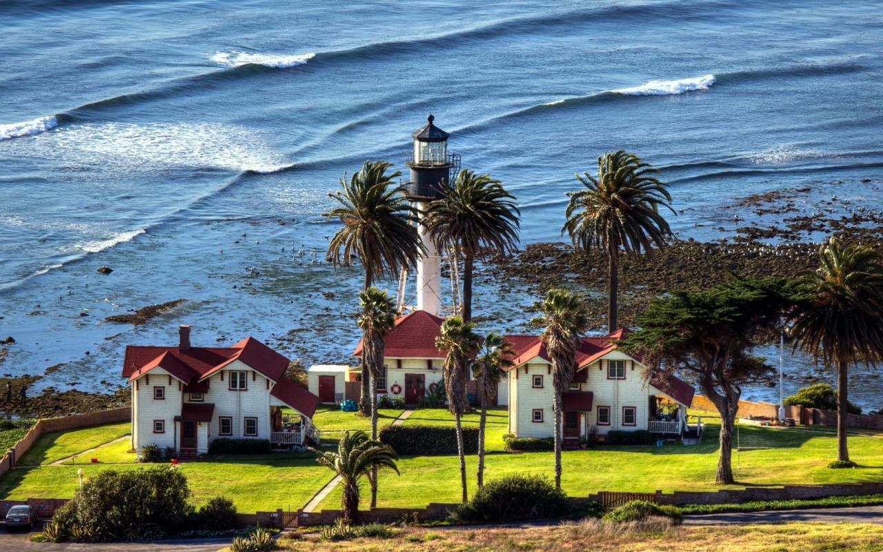 Маяк под пальмами на берегу моря