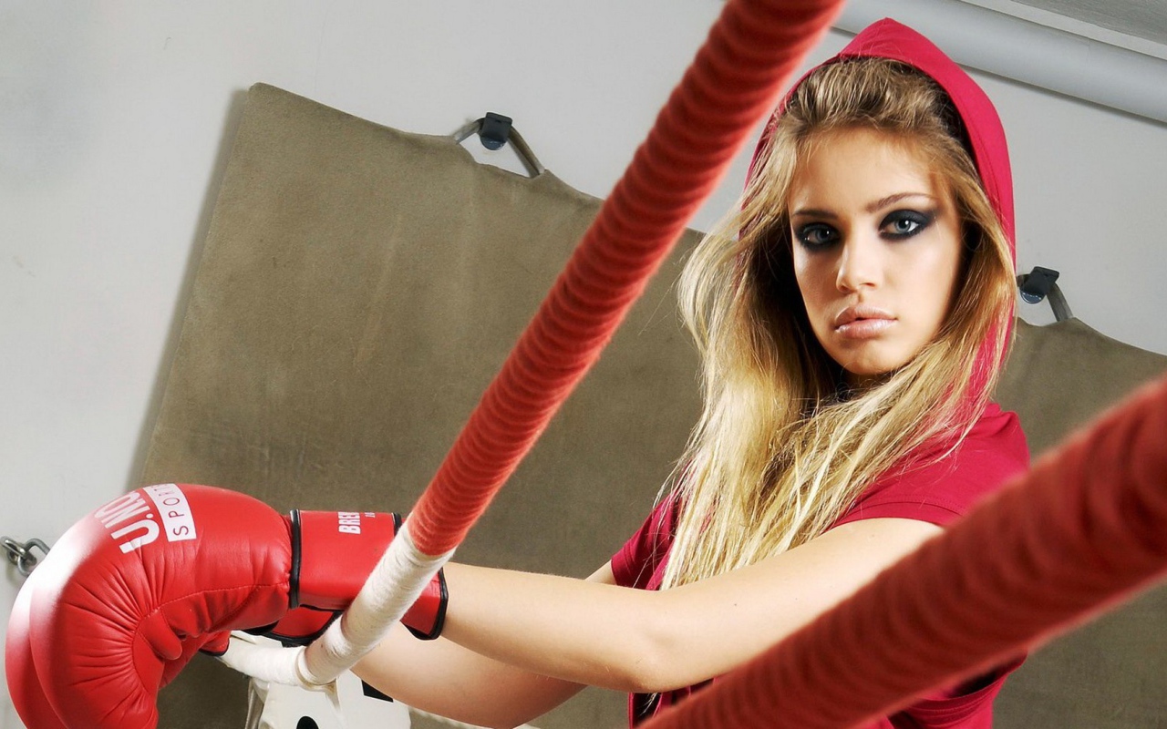 Блондинка в перчатках на боксерском ринге