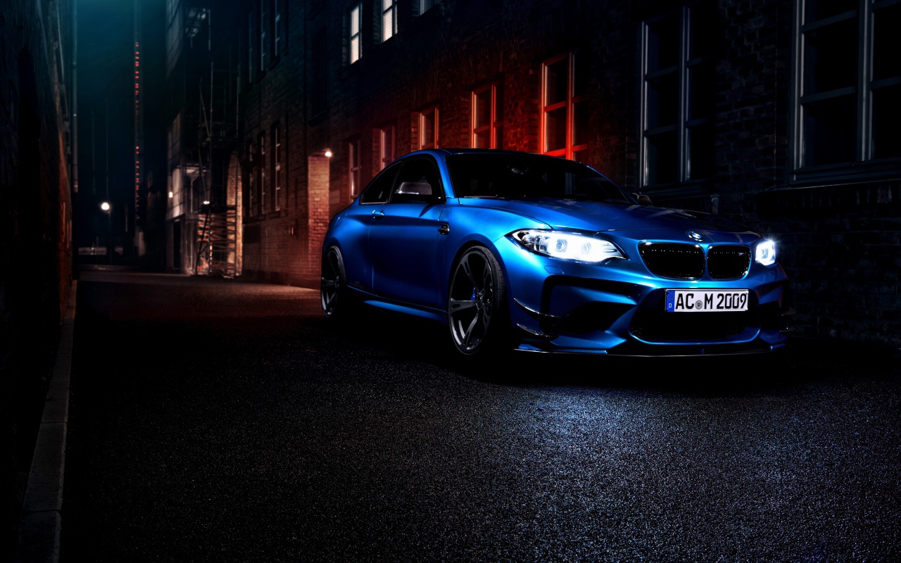 Синий автомобиль BMW M2 на улице города ночью