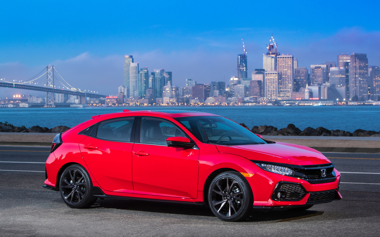 Красный автомобиль Honda Civic Touring Hatchback, 2017 на фоне города 