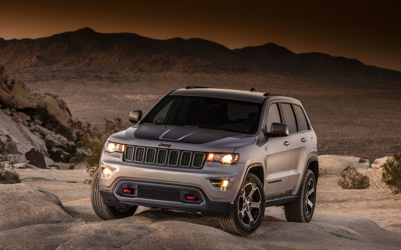 Серебристый внедорожник Jeep Grand Cherokee в пустыне 