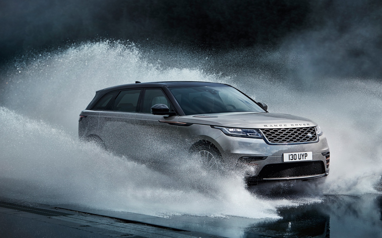 Серый автомобиль Range Rover Velar, 2017 проезжает по воде
