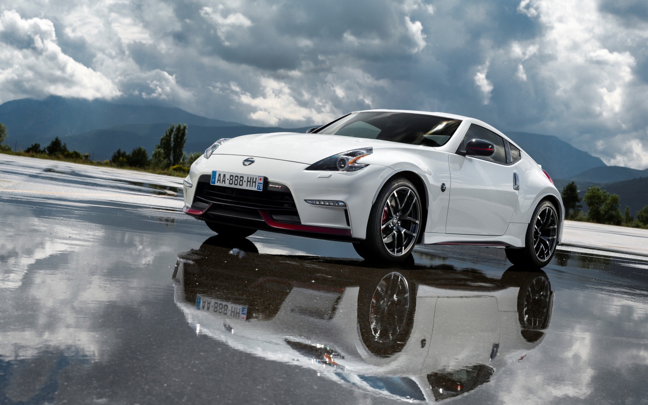 Белый автомобиль Nissan 370z Nismo, 2018 на фоне пасмурного неба