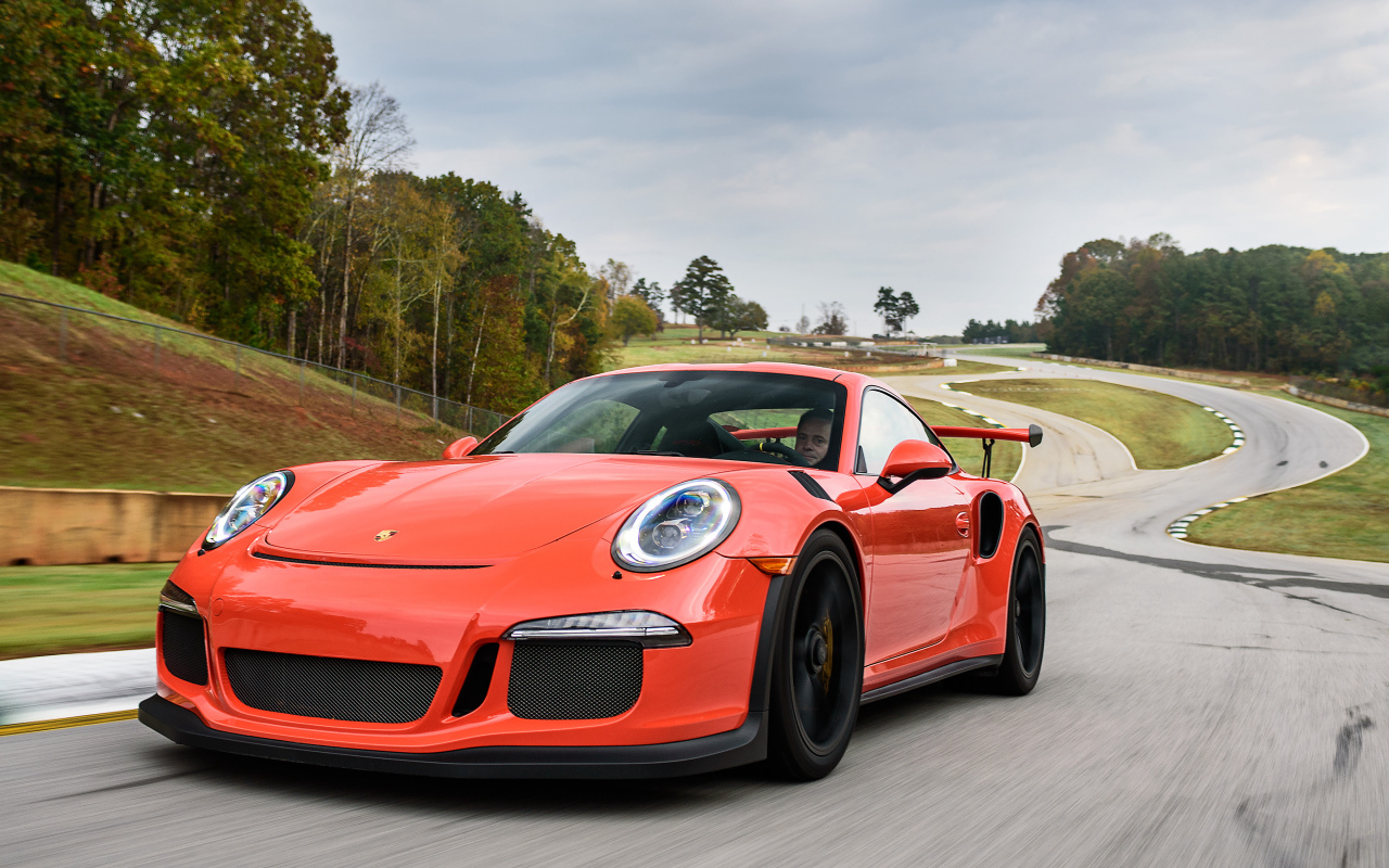 Оранжевый спортивный автомобиль Porsche 911 GT3 на трассе