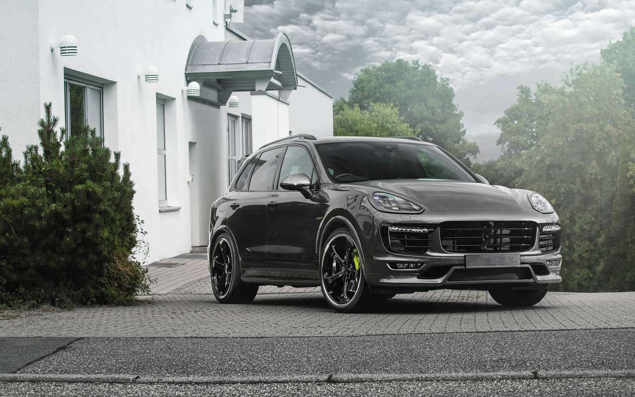 Серебристый автомобиль Porsche Cayenne стоит у дома