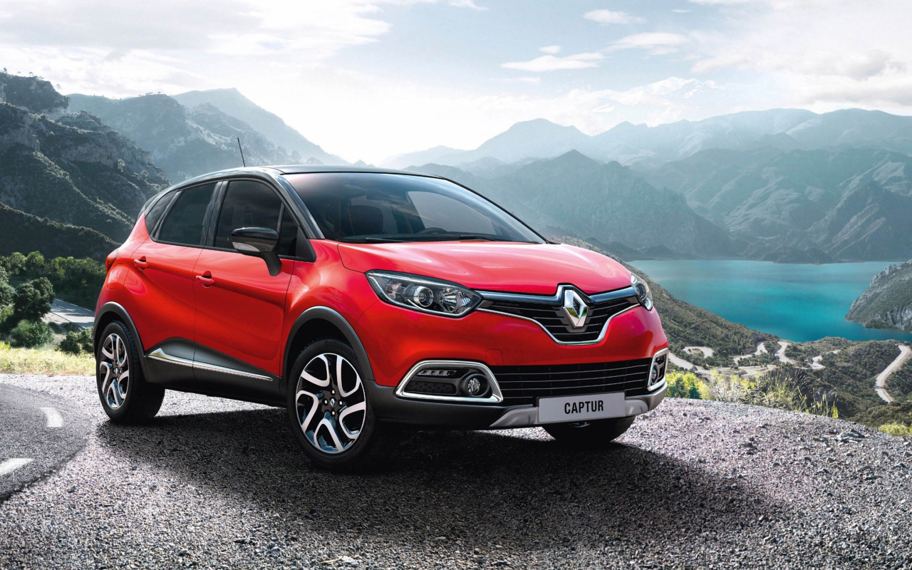 Красный автомобиль внедорожник Renault Captur на фоне гор